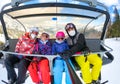 Family riding ski lift cable car on winter vacation skiing wearing masks Royalty Free Stock Photo